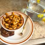 On a plate you have the ingredients to make almond milk, almonds, dates, salt and water on the side.